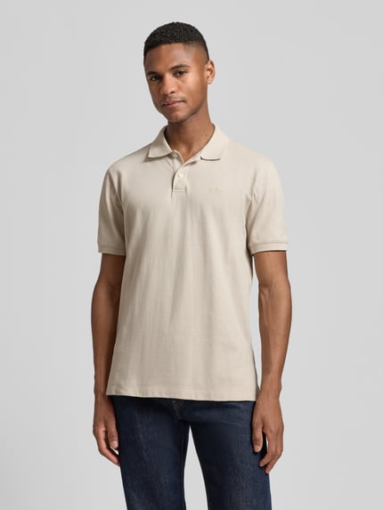 Męski model nosi Slim Fit Poloshirt mit Label-Stitching od GAP, bawełna z domieszką elastanu, krój slim fit, jasnobeżowy, widok z przodu, ujęcie całej sylwetki.