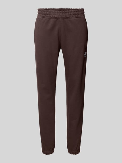 Produktfoto, Sweatpants mit elastischem Bund von adidas Originals aus Baumwoll-Mix, lockerer Schnitt, Eingrifftaschen, Label-Stitching, braune Farbe.