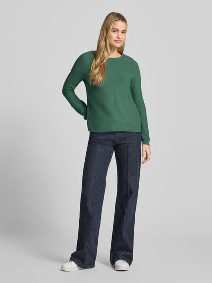 Frauenmodel trägt Pullover aus reiner Baumwolle in Strick-Optik von Christian Berg Woman, grün, strukturierte Oberfläche, Ganzkörperansicht von vorne. Körpernahe Passform, Rundhalsausschnitt, Rückenlänge 58 cm, Ärmellänge 66 cm.