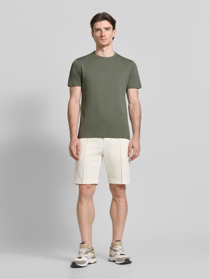 Mannelijk model draagt T-Shirt met Label-Print van Antony Morato, puur katoen, recht model, ronde hals, ruglengte maat M 72 cm, volledig lichaam aan de voorkant.