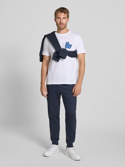 Männermodel trägt Slim Fit Sweatpants aus reiner Baumwolle von Paul Smith in Dunkelblau, glatte Struktur, Ganzkörperansicht von vorne. Herren Sweatpants, Elastikbund mit Tunnelzug, seitliche Eingrifftaschen, Gesäßtaschen, Innenbeinlänge 43 cm in Größe M.