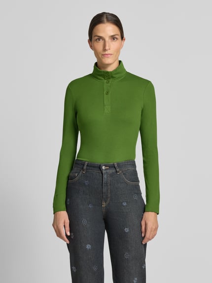 Vrouwenmodel draagt Slim Fit Longsleeve aus Baumwoll-Mix van Marc Cain in elastische katoenmix met opstaande kraag en knoopsluiting, groene kleur, effen textuur, lengte rug maat 36: 55 cm, voorkant volledig zichtbaar, Ganzkörperansicht von vorne.