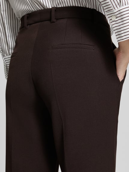 Frauenmodel trägt Regular Fit Schmale Hose mit Viskose-Baumwoll-Anteil Modell 'KRYSTAL' von CAMBIO in Dunkelbraun, Detailaufnahme, Damen Schmale Hose von CAMBIO.
