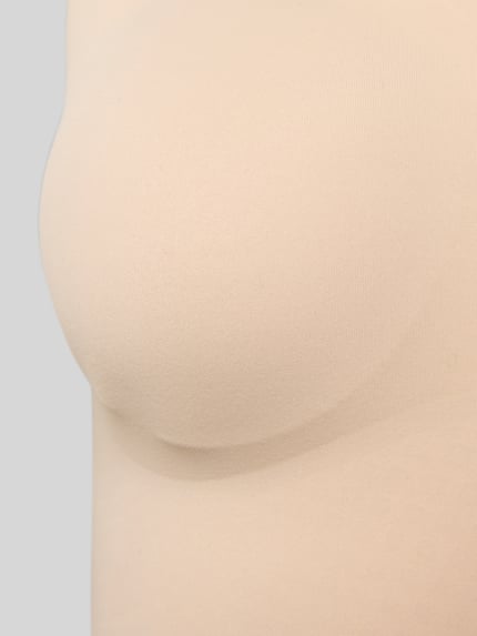 Frauenmodel trägt Slim Fit Top mit V-Ausschnitt Modell 'Invisible' von Schiesser z elastycznej mieszanki materiałów w kolorze beżowym, Ganzkörperansicht von vorne.