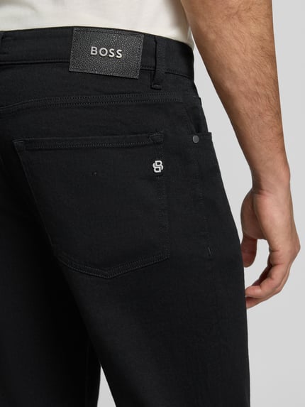 Männermodel trägt schwarze Straight Fit Jeans aus Baumwoll-Mix Modell 'Re.Maine' von BOSS, Nahaufnahme Rückansicht, Herren Straight Fit Jeans von BOSS.