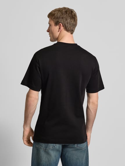 Männermodel trägt Regular Fit T-Shirt mit Logo-Print Modell 'True' von G-Star Raw, Rundhalsausschnitt, Rückenlänge 66 cm, Ganzkörperansicht Rückansicht.