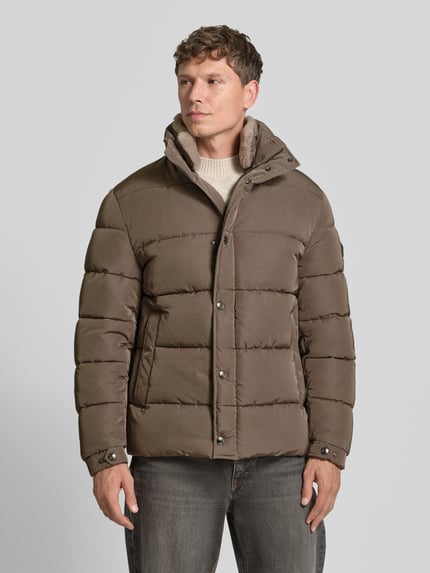 Männermodel trägt Steppjacke mit hohem Stehkragen Modell 'JO-342Newton' von JOOP! COLLECTION, unifarben, mit Knopfleiste, Seitentaschen, Ganzkörperansicht von vorne.