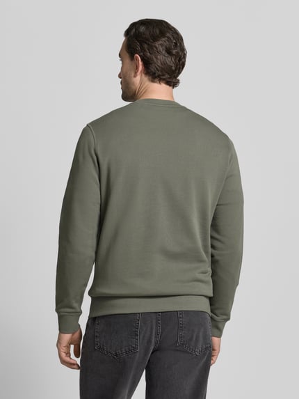 Männermodel trägt Relaxed Fit Sweatshirt aus reiner Baumwolle Modell 'WESTART' von BOSS Orange, unifarben, Label Patch, Ganzkörperansicht Rückansicht.