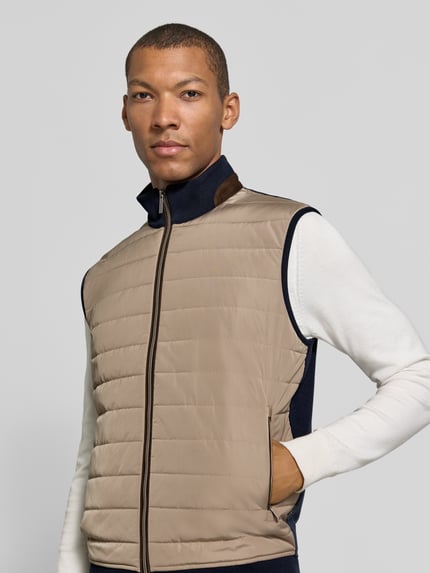 Männermodel trägt Steppweste mit Stehkragen und Eingrifftaschen von bugatti, beige, Baumwoll-Mix, gerader Schnitt, Ganzkörperansicht von vorne.