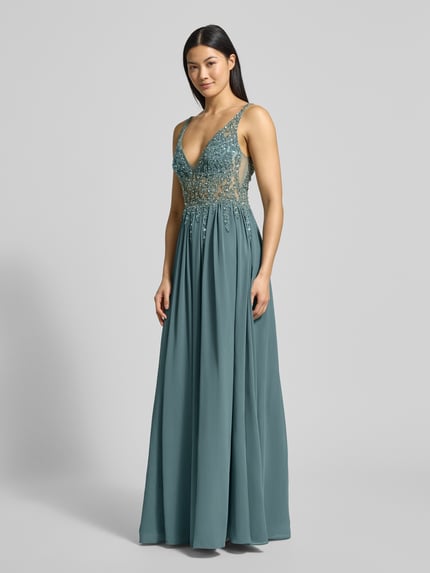 Frauenmodel trägt Abendkleid mit Ziersteinen von Mascara in Petrol, taillierte Passform, V-Ausschnitt, doppellagiger Rockteil, Ganzkörperansicht von vorne.