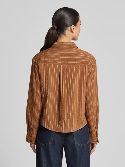 Frauenmodel trägt Hemdbluse mit Strasssteinbesatz Modell 'PUNA' von Mango aus Viskose-Mix in Braun mit feinen Streifen, Regular-Fit, Hemdblusenkragen, Knopfleiste, Brusttasche, Sportmanschetten, leicht abgerundeter Saum, Rückenlänge bei Größe S: 58 cm, Ärmellänge bei Größe S: 59 cm, Ganzkörperansicht Rückansicht.