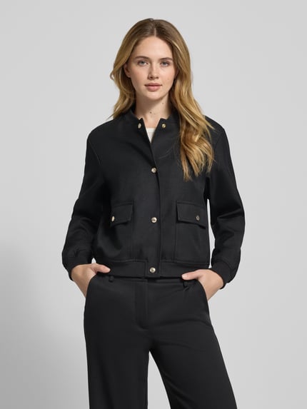 Frauenmodel trägt Jacke mit Stehkragen Modell 'Orlanda' von JOOP!, Regular-Fit, Knopfleiste, Pattentaschen, Schwarz, Ganzkörperansicht von vorne, Rückenlänge bei Größe 36: 53 cm, Schulterbreite 44 cm, Brustweite 53 cm, Ärmellänge 59 cm.