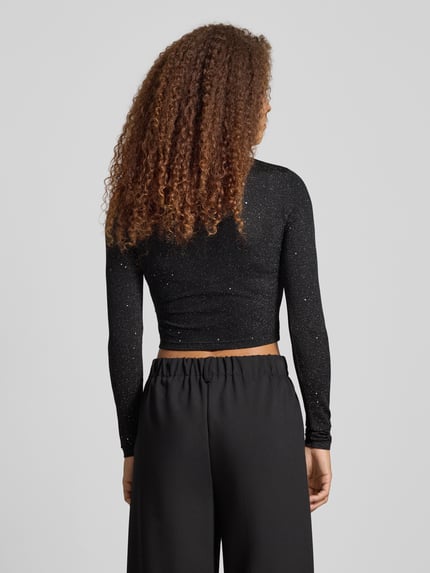 Frauenmodel trägt Cropped Longsleeve mit Label-Detail von Karo Kauer, schwarzer Glitter-Effekt, Material-Mix, Regular Fit, Ganzkörperansicht Rückansicht
