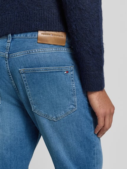 Männermodel trägt Straight Leg Jeans aus Baumwoll-Mix Modell 'DENTON' von Tommy Hilfiger, Optik: Unifarben, Detailaufnahme Rückansicht.