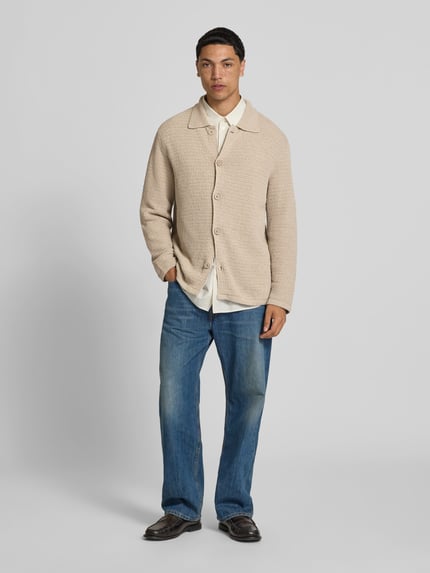 Mannenmodel draagt cardigan uit katoenmix van closed in beige met structuurpatroon, platte kraag en doorlopende knoopsluiting, los model, ruglengte maat M 70 cm, schouderbreedte 47 cm, mouwlengte 67 cm, lichte textuur, volledige lichaamsaanzicht van voren.