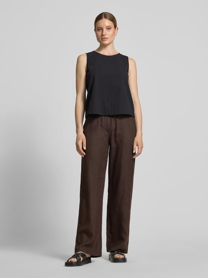 Frauenmodel trägt weite Damen Leinenhose mit Bindegürtel Modell 'Chiara' von MAC in Braun mit französischen Eingrifftaschen, Ganzkörperansicht von vorne.