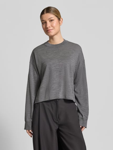 Vrouwenmodel draagt gebreide pullover uit zuivere scheerwol relaxed fit Model 'MALESE' van DRYKORN, ronde hals, grijs, vooraanzicht, context: dames gebreide pullover van DRYKORN, ruglengte maat S 49 cm, mouwlengte maat S 52 cm.