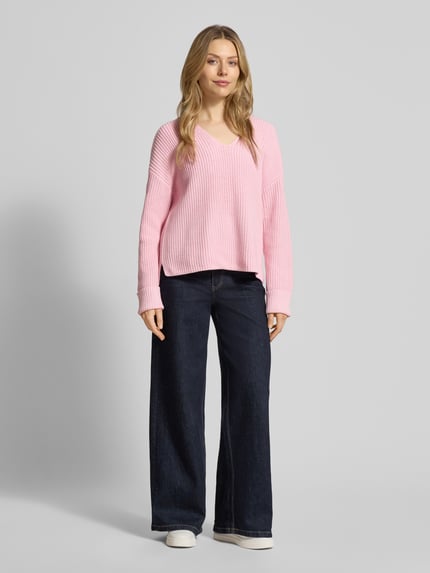 Frauenmodel trägt Oversized Strickpullover aus Baumwoll-Mix von s.Oliver RED LABEL in Rosa, unifarben, gerippte 3/4-Ärmel, Ganzkörperansicht von vorne.