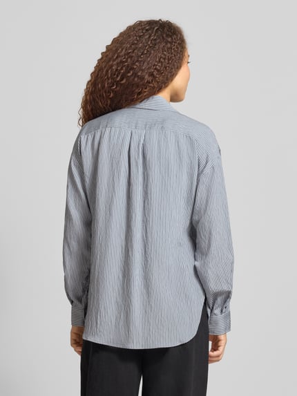 Frauenmodel trägt Regular Fit Langarmbluse aus Viskose-Mix von Marc O'Polo in Two-Tone-Optik mit Streifenmuster, Rückenpasse, Popeline, Ganzkörperansicht Rückansicht.