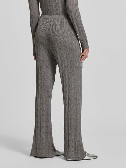 Frauenmodel trägt Relaxed Fit Strickhose mit Viskose-Anteil von Jake*s Collection, grauer Material-Mix mit semitransparenter Optik, integrierte Shorts, elastischer Bund, Ganzkörperansicht Rückansicht.
