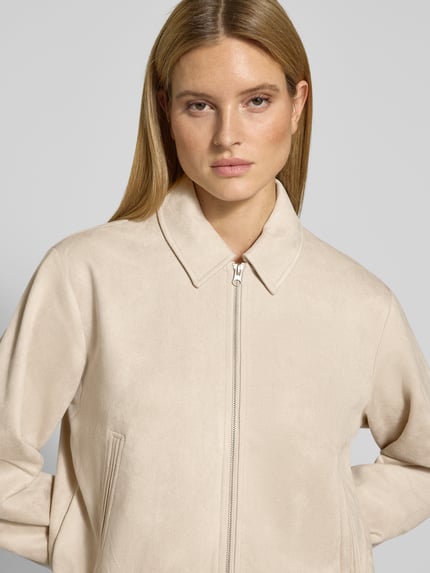 Kobiece modelka nosi Jacke in Leder-Optik mit Eingrifftaschen Modell 'DUVA' od FREE/QUENT, beż, krój regular fit, zbliżenie na górną część ciała
