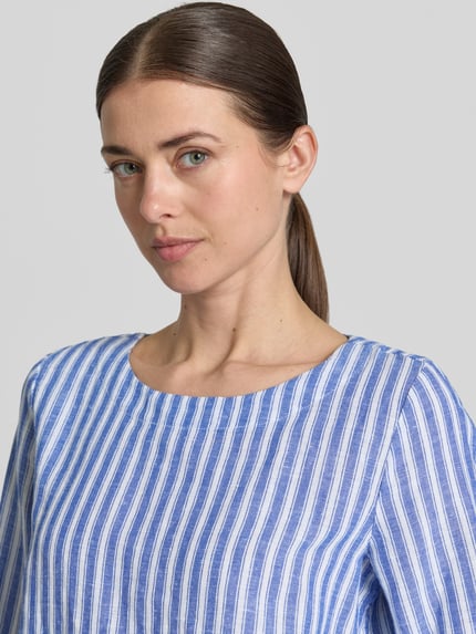 Frauenmodel trägt Regular Fit Leinenbluse mit 3/4-Arm von Christian Berg Woman, blaue und weiße Streifen, Rundhalsausschnitt, Reines Leinen, Nahaufnahme Oberkörper.
