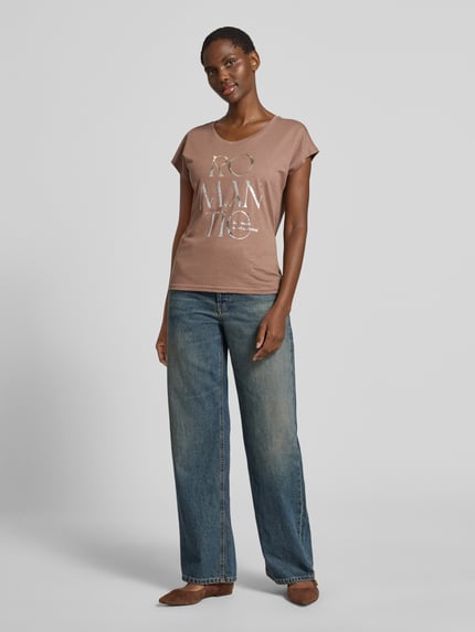 Frauenmodel trägt Regular Fit T-Shirt aus Viskose-Mix mit Statement-Print von Christian Berg Woman, Damen T-Shirt in Braun mit Rundhalsausschnitt und Rückenlänge 56 cm bei Größe S, Ganzkörperansicht von vorne.