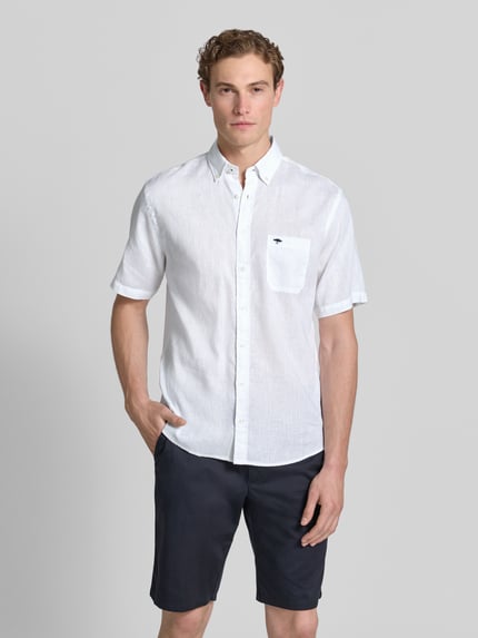 Männermodel trägt Slim Fit Freizeithemd aus Leinen-Baumwoll-Mix von Fynch-Hatton in Weiß mit Button-Down-Kragen, Brusttasche, Label-Stitching, Knopfleiste, Rückenlänge 74 cm, Schulterbreite 48 cm, Ärmellänge 26 cm, Ganzkörperansicht von vorne.