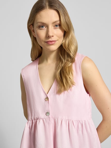 Frauenmodel trägt Top aus Leinen-Mix mit Viskose-Anteil von Christian Berg Woman Selection in zartem Rosa mit Knopfverschluss und Raffungen, taillierte Passform, Nahaufnahme Oberkörper. Rückenlänge bei Größe 36: 61 cm, Schulterbreite: 40 cm, Brustweite: 45 cm.