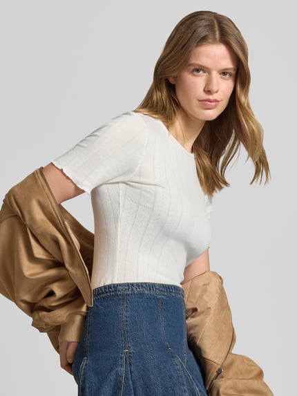 Vrouwenmodel draagt Slim Fit T-Shirt uit katoenmix model 'TENNA' van Only, effen wit, ronde hals, korte frillmouwen, vooraanzicht close-up