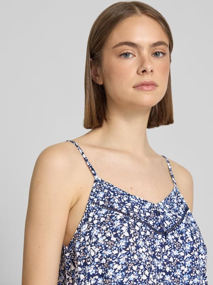 Kobiece modelka nosi Regular Fit Blusentop aus reiner Viskose Modell 'NALA LIFE' od Only, niebiesko-białe allover-motyw, regulowane cienkie ramiączka, V-dekolt, materiał: czysta wiskoza, krój regular fit, zbliżenie na górną część ciała