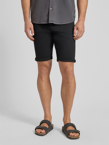 Männermodel trägt Regular Fit Jeans Bermudas aus Baumwoll-Mix von Tom Tailor in dunklem Denim mit 5-Pocket-Design, Nahaufnahme Oberschenkel.