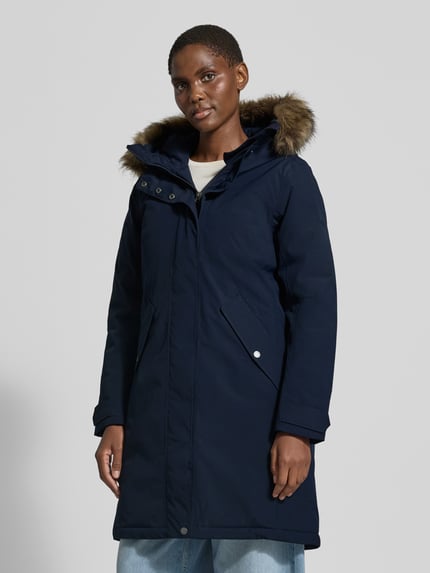 Frauenmodel trägt Regular Fit Parka mit Kunstfellbesatz Modell 'ERNA' von Didriksons in Dunkelblau, Thermore Füllung, Ganzkörperansicht von vorne. Rückenlänge 93 cm, Schulterbreite 42 cm, Brustweite 51 cm, Ärmellänge 66 cm, 10.000mm Wassersäule, Kapuze.