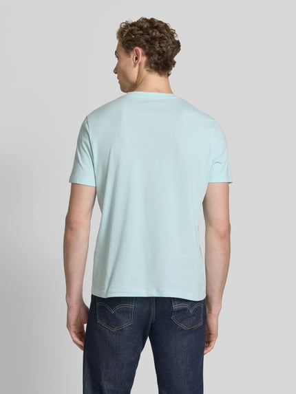 Männermodel trägt Regular Fit T-Shirt aus reiner Baumwolle von s.Oliver RED LABEL in Hellblau, glatte Baumwollstruktur, Ganzkörperansicht Rückansicht.