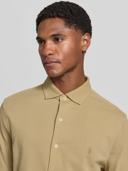 Männermodel trägt Slim Fit Freizeithemd aus reiner Baumwolle von Polo Ralph Lauren in Beige, glatte Textur, Nahaufnahme Oberkörper, Herren Freizeithemd von Polo Ralph Lauren.