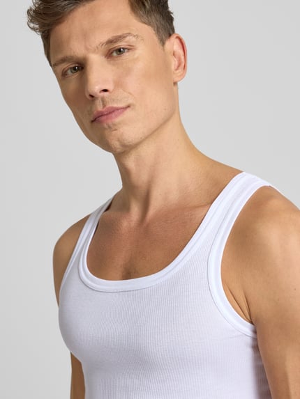Męski model nosi Tanktop in Ripp-Optik od Götzburg Wäsche, biały, slim fit, bawełna, okrągły dekolt, zbliżenie na górną część ciała.