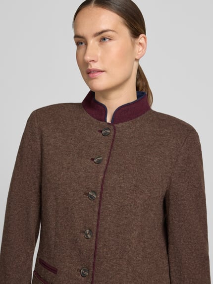 Modelka kobieca nosi Slim Fit Blazer aus Lanawolle-Mix mit Stehkragen von White Label, brązowy, burgundowe lamówki, guziki, krój slim fit, rozmiar 36: długość 70 cm, szerokość w rozmiarze 50 cm, długość rękawa 63 cm, zbliżenie na górną część tułowia.