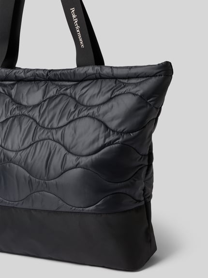 Produktfoto, Tote Bag mit Reißverschluss Modell 'HELIUM' von Peak Performance in Schwarz mit gesteppten Wellen, Logo-Print, glatte Textur