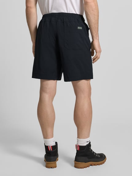 Männermodel trägt Regular Fit Shorts mit Logo-Patch Modell 'Landroamer' von COLUMBIA aus Elastischer-Material-Mix, AufgesetzteTaschen, Elastischer Bund, Knopf-Reißverschluss, Farbe Dunkel, Struktur glatt, Ganzkörperansicht Rückansicht.