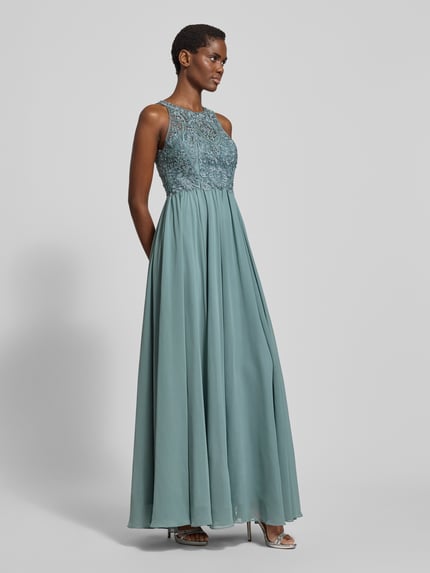 Frauenmodel trägt Abendkleid mit Strasssteinen von LAONA in Blaugrün aus Tüll mit floraler Spitze, taillierter Schnitt, Ganzkörperansicht von vorne.