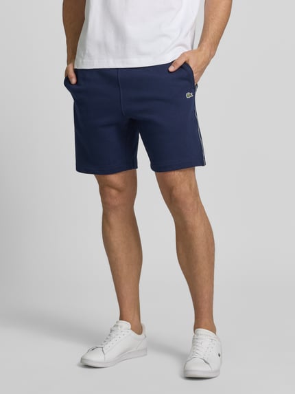 Männermodel trägt Regular Fit Sweatshorts aus reiner Baumwolle von Lacoste, Optik: Unifarben, 5-Pocket-Design, Sweat, Nahaufnahme Unterkörper.