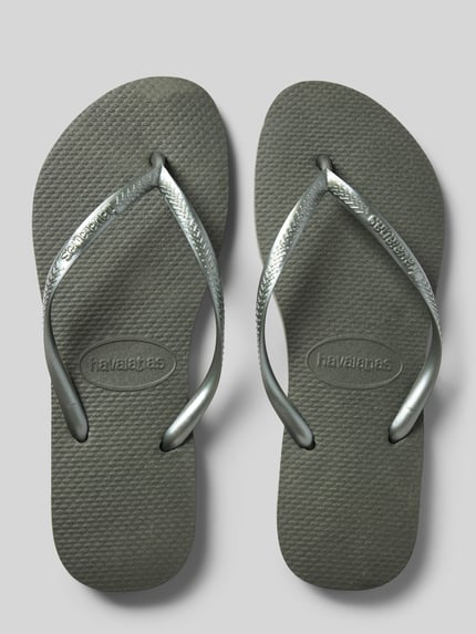 Produktfoto, graue Flip-Flops mit Logo-Detail von Havaianas, abgerundete Passform, offene Ferse, Zehentrenner, Absatzhöhe 1 cm bei Größe 39/40, strukturierte Oberfläche.