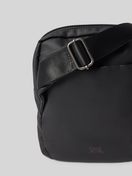 Produktfoto, Crossbody Bag mit Statement-Print Modell 'EXPLORE' von camel active, schwarze Tasche mit Rundum-Reißverschluss und verstellbarem Schulterriemen, Detailaufnahme, Herren Crossbody Bag