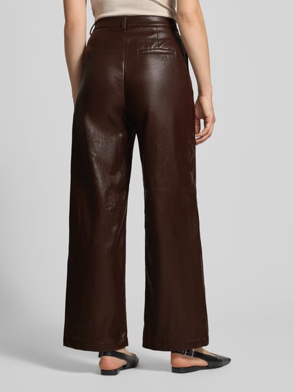 Frauenmodel trägt Wide Leg Kunstlederhose mit Gürtelschlaufen von Jake*s Casual in Dunkelbraun, glatte Textur, Ganzkörperansicht Rückansicht.