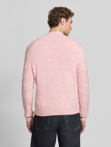 Mannelijk model draagt Regular Fit Strickpullover met geripte ribboorden van MCNEAL uit elastische materiaalmix met wol, ruglengte 68 cm, mouwlengte 67 cm, pullover met ronde hals, lichtroze kleur, grof gebreide textuur, Ganzkörperansicht Rückansicht.
