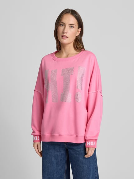 Frauenmodel trägt Sweatshirt mit Label-Detail von miss goodlife in Pink, lockerer Schnitt, reine Baumwolle, Nahaufnahme Oberkörper.