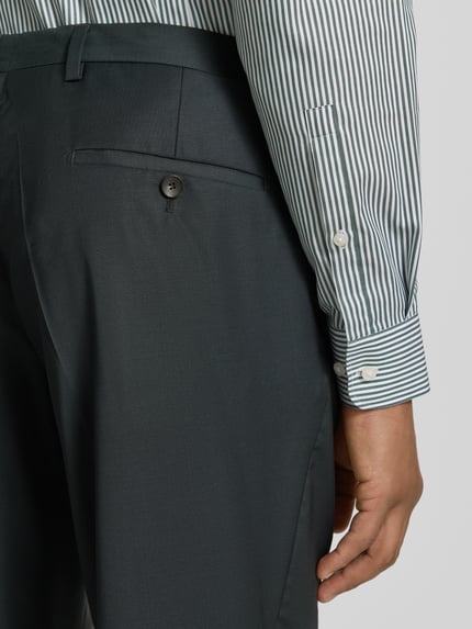 Männermodel trägt Regular Fit Anzughose aus Viskose Modell 'Chaz' von CG - Club of Gents, Bundfalten, Eingrifftaschen, Detailaufnahme Rückansicht.