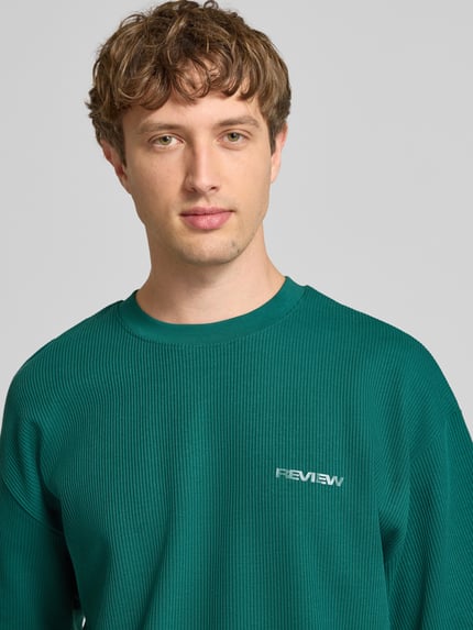 Männermodel trägt Relaxed Fit T-Shirt mit Strukturmuster von REVIEW in Grün, Reine Baumwolle, Rundhalsausschnitt, Nahaufnahme Oberkörper.