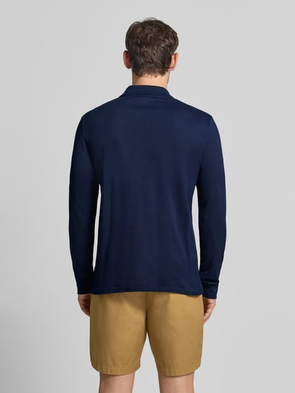Männermodel trägt Regular Fit Poloshirt aus reiner Baumwolle von Lacoste in Dunkelblau, glatte Struktur, Ganzkörperansicht Rückansicht.