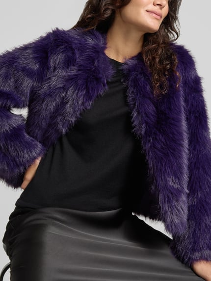 Frauenmodel trägt Webpelzjacke mit cropped Länge von JOOP!, unifarben violett, strukturierte Optik, Nahaufnahme Oberkörper.